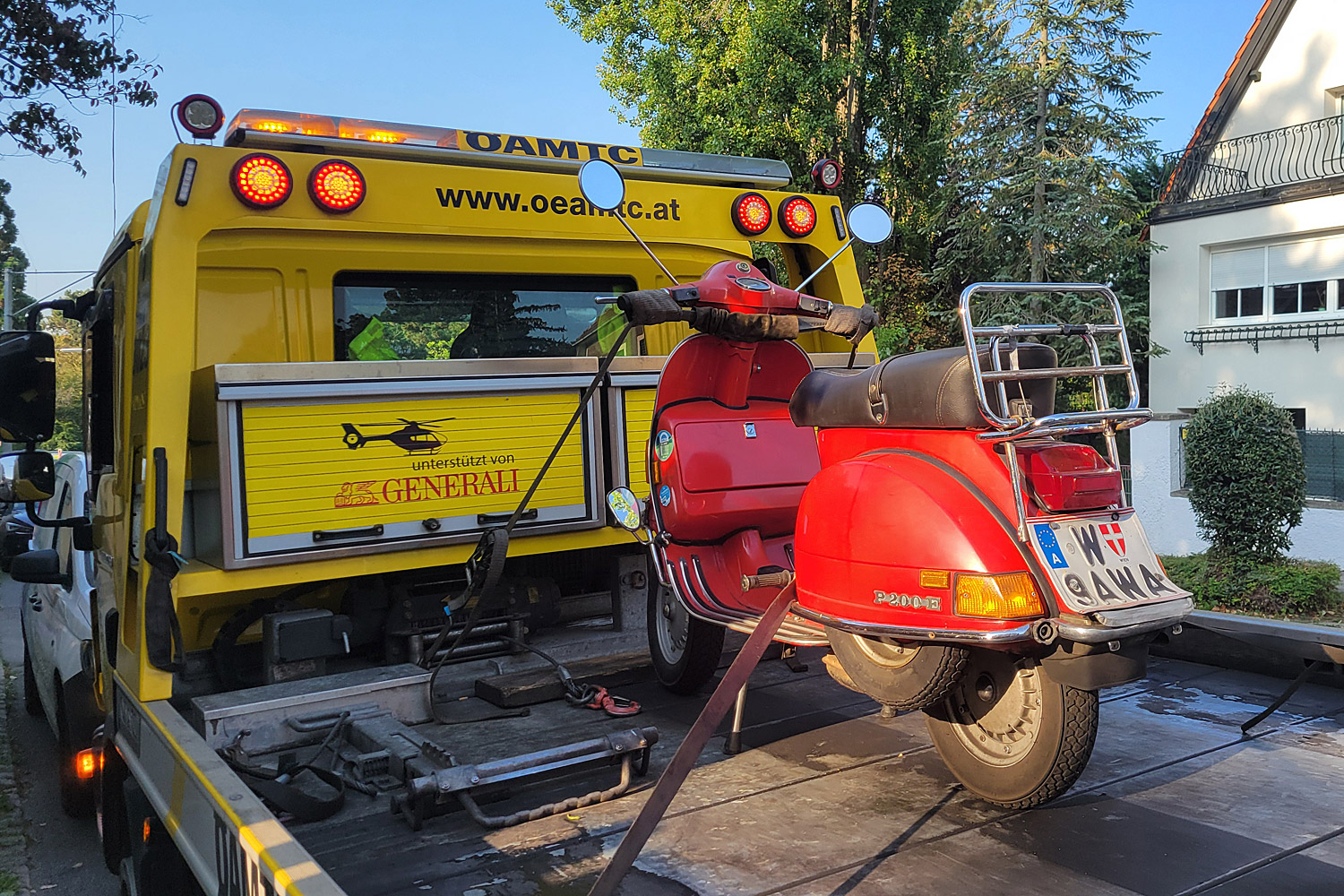 Rote Vespa wird von LKW des Autombilclubs abgeschleppt.